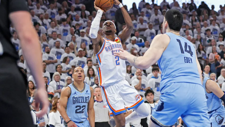 奧克拉荷馬雷霆隊後衛Shai Gilgeous-Alexander（2號）在2025年4月20日（星期日）舉行的NBA首輪季後賽第一戰上半場比賽中，試圖在曼菲斯灰熊隊後衛Desmond Bane（22號）與中鋒Zach Edey（14號）之間出手投籃，地點位於奧克拉荷馬市。